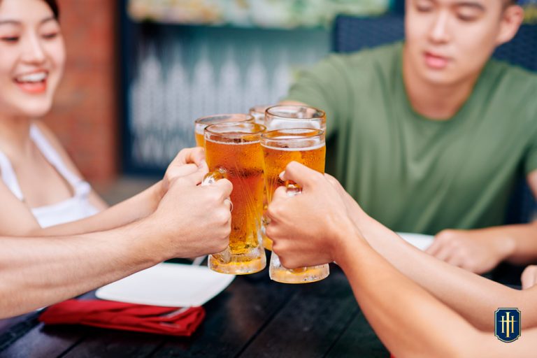 Grupo de pessoas contendo homens e mulheres tomando cerveja.