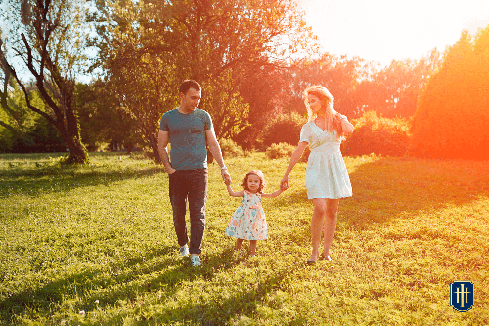 Um casal com sua filha pequena passeando busque.