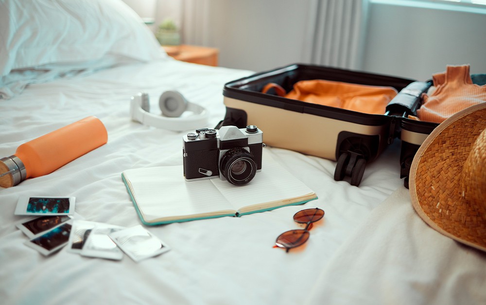 cliente arrumando sua mala para sua estadia, levando sua câmera para realizar fotografia no hotel.