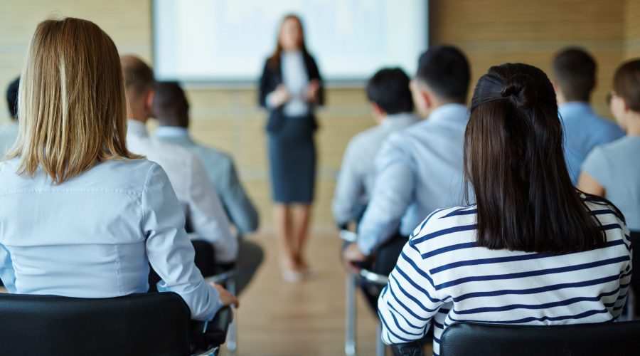Rear view of people sitting at business seminar