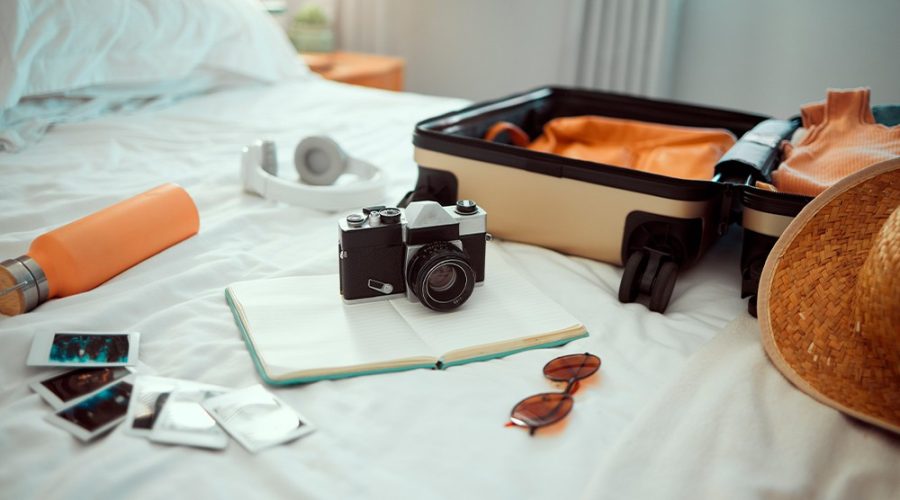 cliente arrumando sua mala para sua estadia, levando sua câmera para realizar fotografia no hotel.
