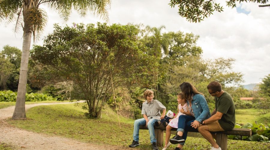 Família sentada em um banco na natureza