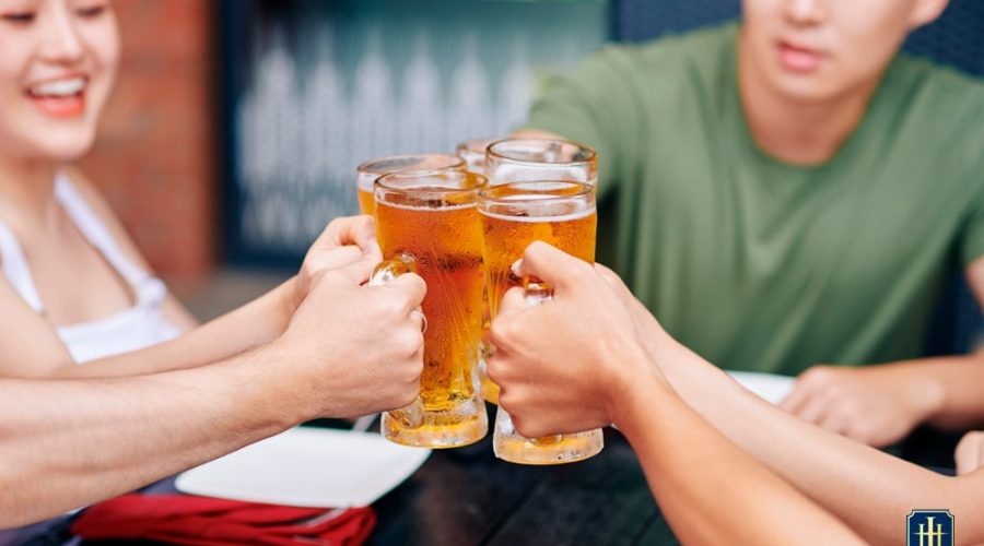 Grupo de pessoas contendo homens e mulheres tomando cerveja.