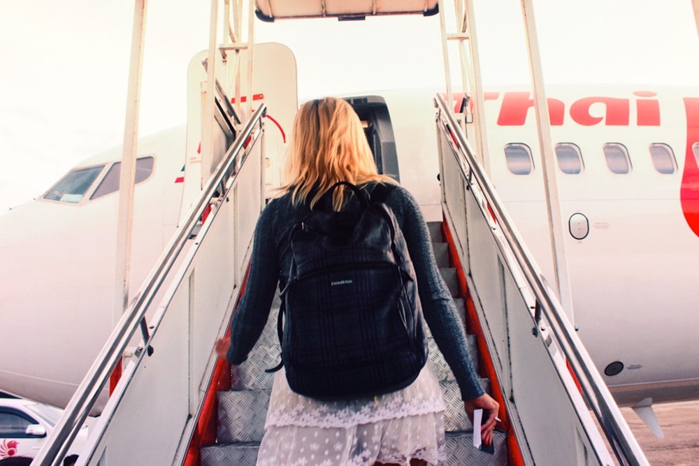 mulher subindo no avião para viajar