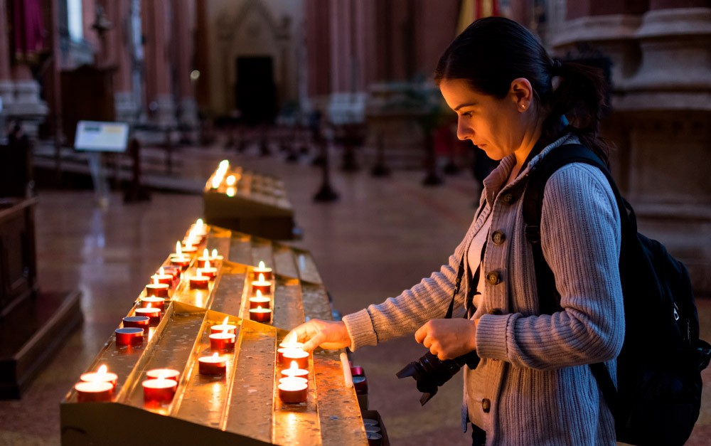 Mulher acendendo vela em igreja